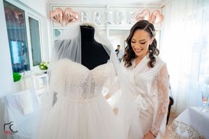 Bridal boutique interior with white wedding gowns and rose gold decor.