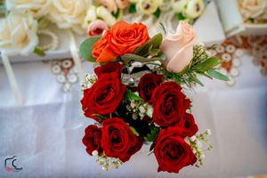 Wedding flower arrangement with red and peach roses creating beautiful color contrast.