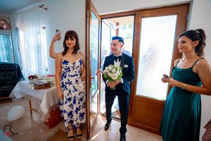 Wedding party members gathered in a room with natural lighting and wooden accents.