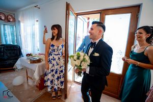 Pre-wedding scene with attendants in teal and floral dresses preparing in a bright room.