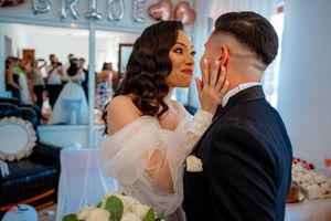 A candid wedding photo showing an emotional moment between the couple with soft lighting and floral decor.