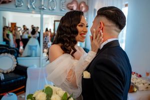 A joyful wedding scene with the couple sharing a tender moment beneath decorative balloon letters.