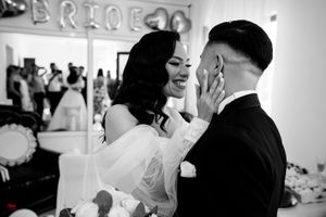 Monochrome wedding photograph capturing a spontaneous moment of joy between the newlyweds.