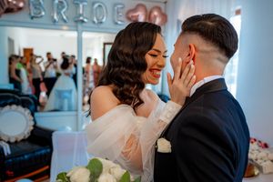 An emotional wedding moment captured in vibrant color with a 'BRIDE' sign and floral decorations.