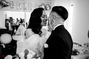 A black and white wedding photo showing pure joy and emotion during an intimate moment.