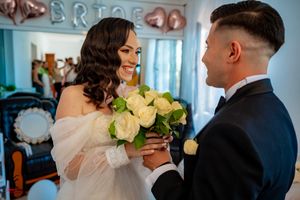 A romantic moment between newlyweds exchanging flowers during their wedding celebration.