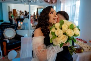 An emotional wedding scene with a stunning white rose bouquet and soft tulle dress details.