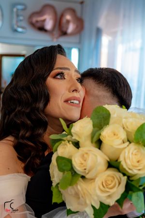 A close-up capture showing elegant wedding makeup and a luxurious cream rose bouquet.