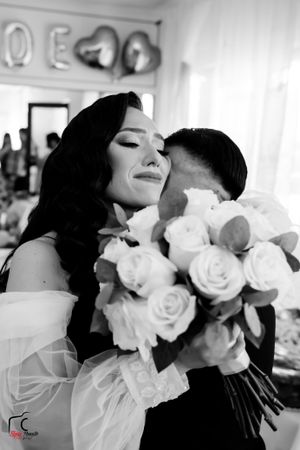A black and white portrait capturing a tender wedding moment with elegant roses.