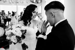 A black and white wedding portrait showing an emotional moment between the couple.