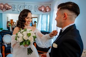 Wedding celebration featuring elegant white roses and rose gold balloon decorations.