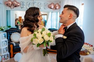 Indoor wedding scene with romantic decorations and a beautiful white rose bouquet.