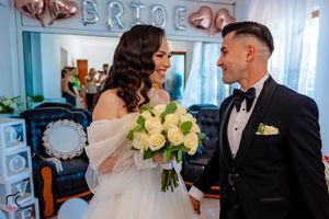 Intimate wedding moment captured with rose gold balloon decor and white floral arrangements.
