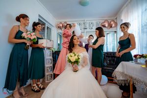 Wedding party members sharing joyful moments in a sunlit room with floral decorations.