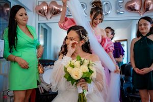 Bridal party celebrating in a light-filled room with decorative wall art.