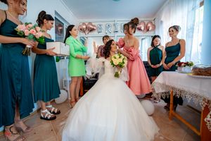 Bridal preparation scene with attendants in coordinated dresses and decor.
