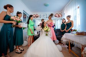 Bridal party members gather in a room with festive decorations and balloons for pre-wedding activities.