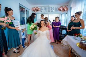Bridal party gathering in room decorated with metallic balloons spelling 'BRIDE'.