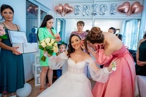 Bridal party members gather under rose gold balloon decorations during pre-wedding preparations.