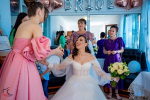 Wedding preparations in a room with blue walls and pink balloon decorations.