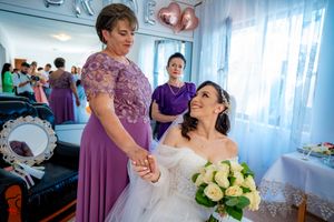 Wedding preparation scene with white-gowned bride and attendants in a blue-walled room.