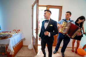 Musicians with accordion perform at a wedding celebration in a bright indoor space.