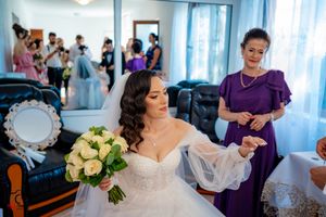 Wedding ceremony preparations in a bright room with elegant decor and blue curtains.