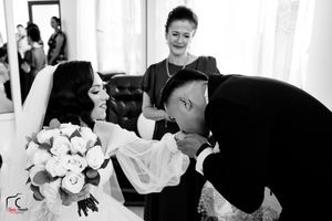 Elegant wedding ceremony with white floral bouquets and formal attire in a light-filled venue.