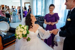 Formal wedding gathering in a bright room with light blue curtains and elegant decor.