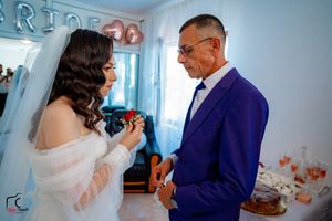 Wedding celebration scene with formal attire against blue interior decor.