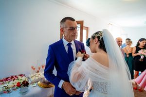 A tender wedding day moment captured in a bright indoor setting with soft lighting and romantic atmosphere.