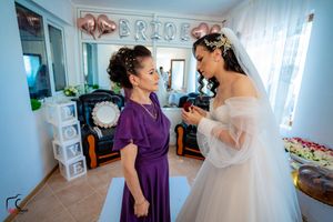 Wedding party members share emotional moments during preparations in a decorated room.
