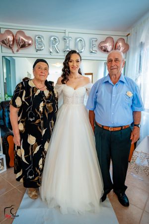 Wedding party posing together under rose gold balloon decorations.
