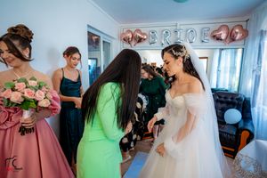 Bridesmaids in colorful dresses assisting during wedding preparations.