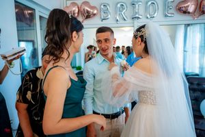 Intimate wedding celebration scene with teal and white decor and rose gold accents.