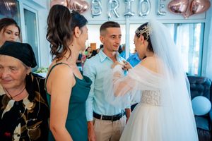 Wedding reception scene with rose gold balloon decorations and light blue walls.