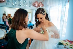 Wedding party members interacting during celebration with BRIDE balloon decor visible.