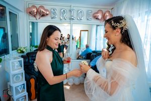 Celebratory wedding moment captured under rose gold balloon decorations.