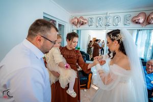 Wedding celebration with a small child in a room decorated with rose gold balloons.