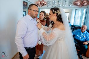 Candid wedding moment captured under rose gold balloon decorations.