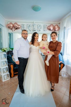 Wedding group photo with elegant decor and rose gold heart balloons.