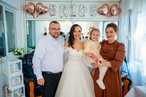 Family gathering at wedding celebration with rose gold balloon decorations.