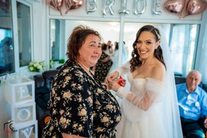 Wedding celebration moment in room with rose gold balloon decor and 'BRIDE' sign.