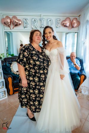 Wedding celebration in a bright room with rose gold 'BRIDE' balloons and guests sharing joyful moments.