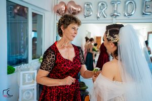 Wedding celebration with guests in sparkly attire gathered under decorative balloon lettering.
