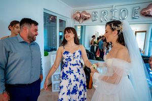 Wedding gathering with guests in blue and gray attire celebrating under balloon decorations.