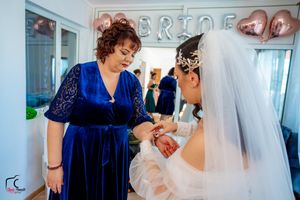 Wedding party scene with elegant blue velvet attire and decorative balloon backdrop.