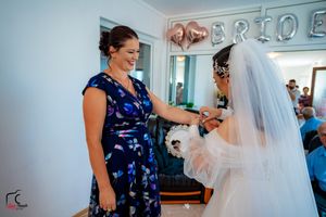 Bridal suite scene with guests in patterned dresses during wedding preparations.