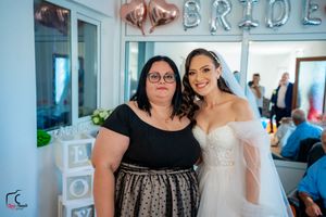 Wedding celebration gathering with formal attire and decorative 'BRIDE' signage on the wall.