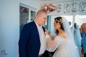 Wedding party members pose for formal photos in a bright indoor venue with modern decor.